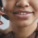 Friendly close-up of a woman with a headset at a call center, showcasing professional demeanor.